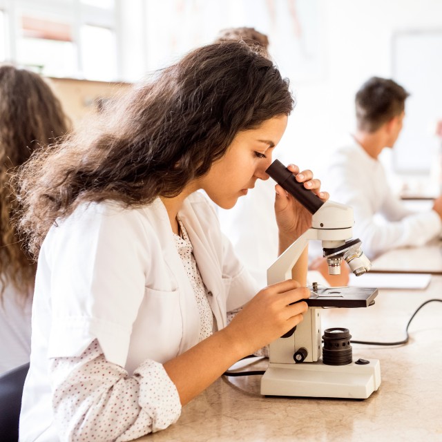 A student looking into a microscope